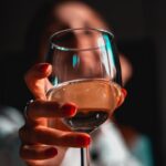 person holding clear wine glass