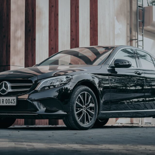 black porsche 911 parked in front of brown wooden wall