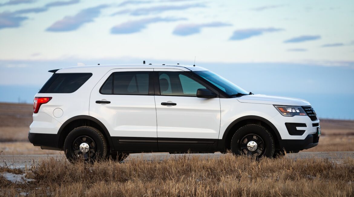 white suv on brown grass field under white clouds during daytime