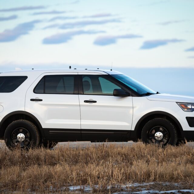 white suv on brown grass field under white clouds during daytime